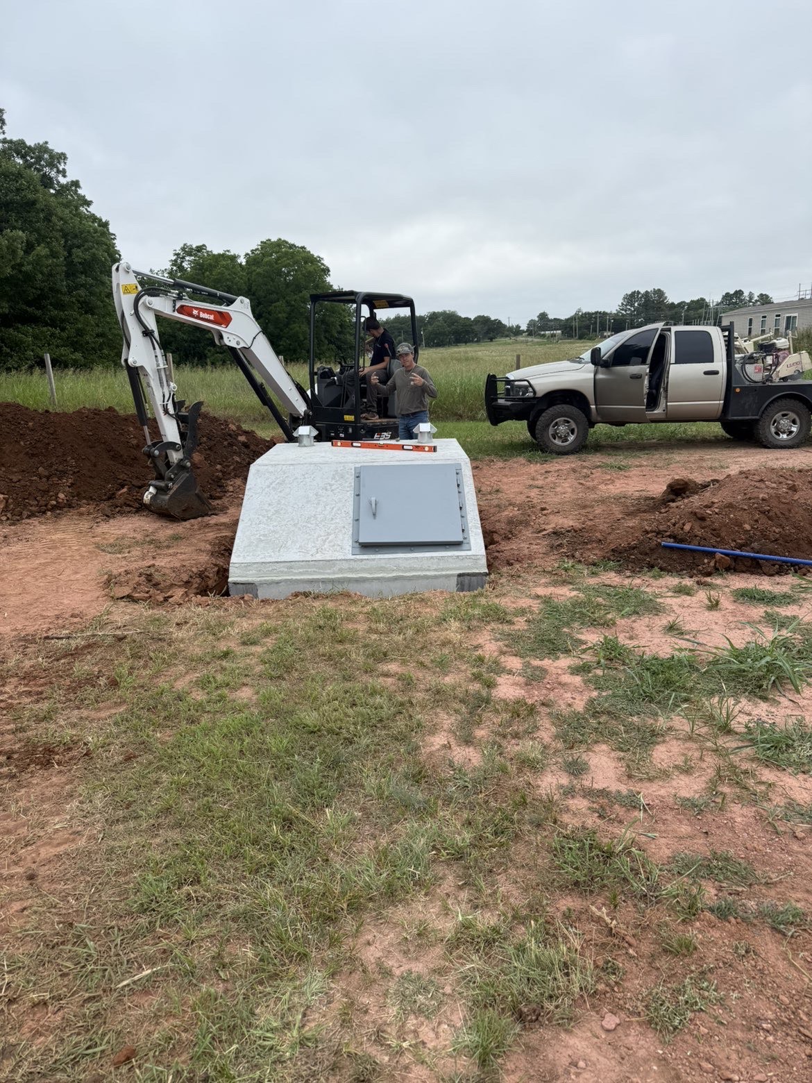 Crew installing a concrete storm shelter